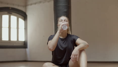 Slow-motion-of-hard-breathing-woman-drinking-water-in-gym